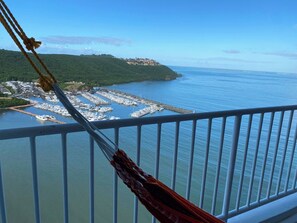 A marina with boats docked, a coastal town in the background, and a clear sky. - Slow Down & Relax Ocean, Marina, and Mountain Views! (Fajardo)