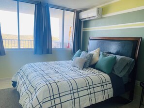 A bedroom with a bed, curtains, an air conditioning unit, and a view of the outdoors. - Slow Down & Relax Ocean, Marina, and Mountain Views! (Fajardo)