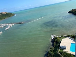A marina with boats docked, a pier extending into the water, and a building with a pool. - Slow Down & Relax Ocean, Marina, and Mountain Views! (Fajardo)