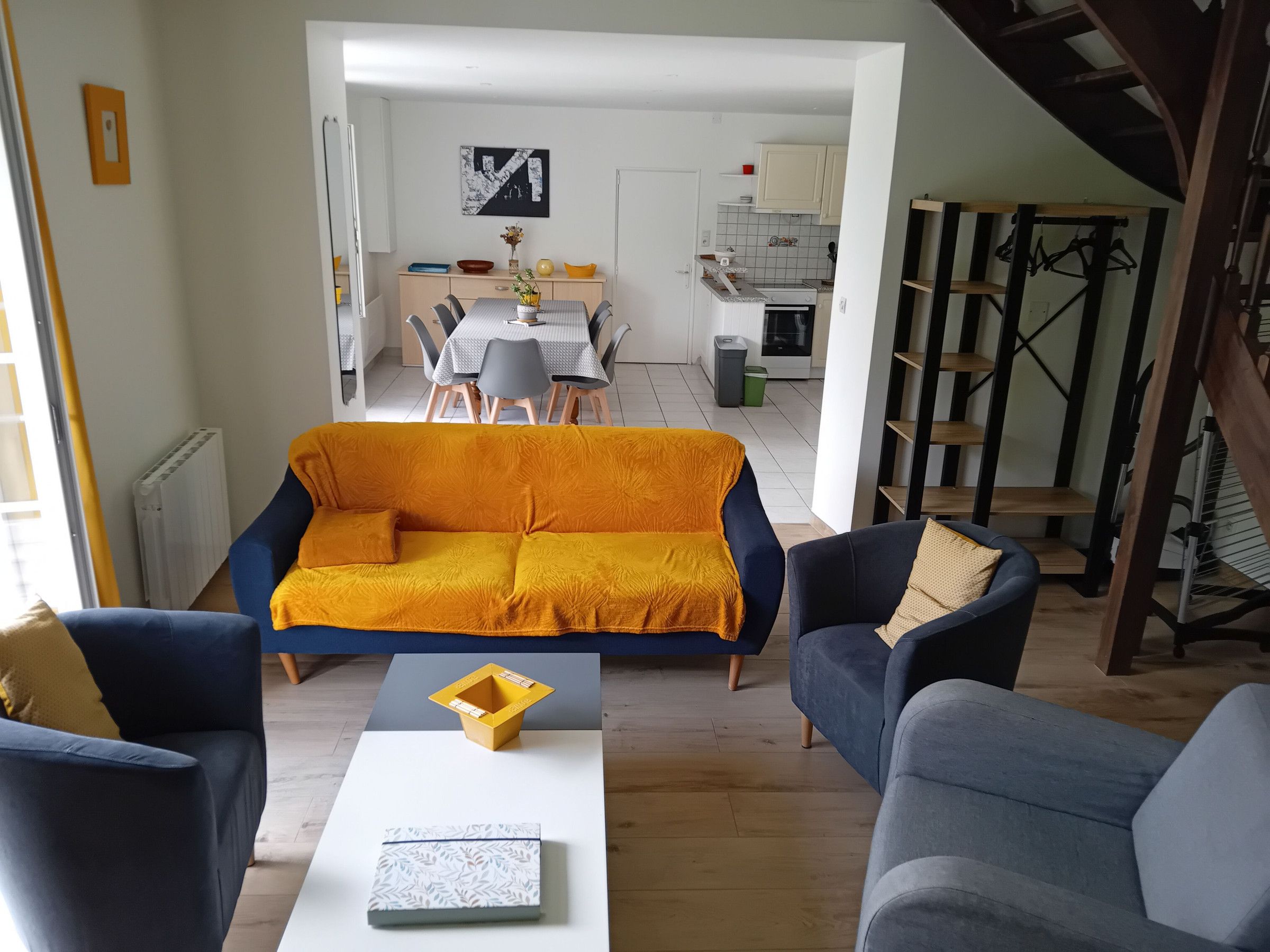 Una sala de estar moderna con un sofá, sillas y una mesa de centro.