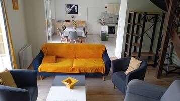 Una sala de estar moderna con un sofá, sillas y una mesa de centro.