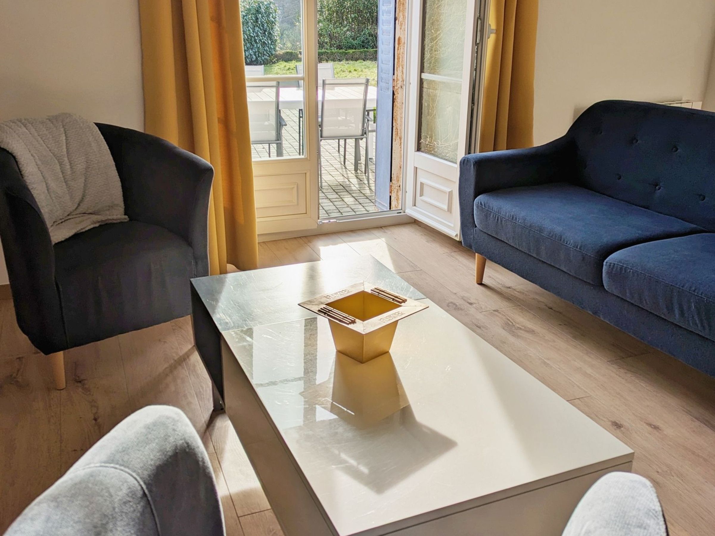 A room with a sofa, a chair, and a coffee table.