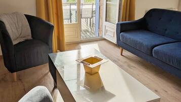 A room with a sofa, a chair, and a coffee table.