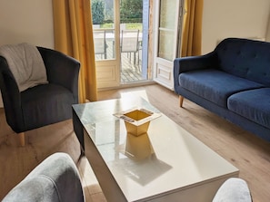 A room with a sofa, a chair, and a coffee table.