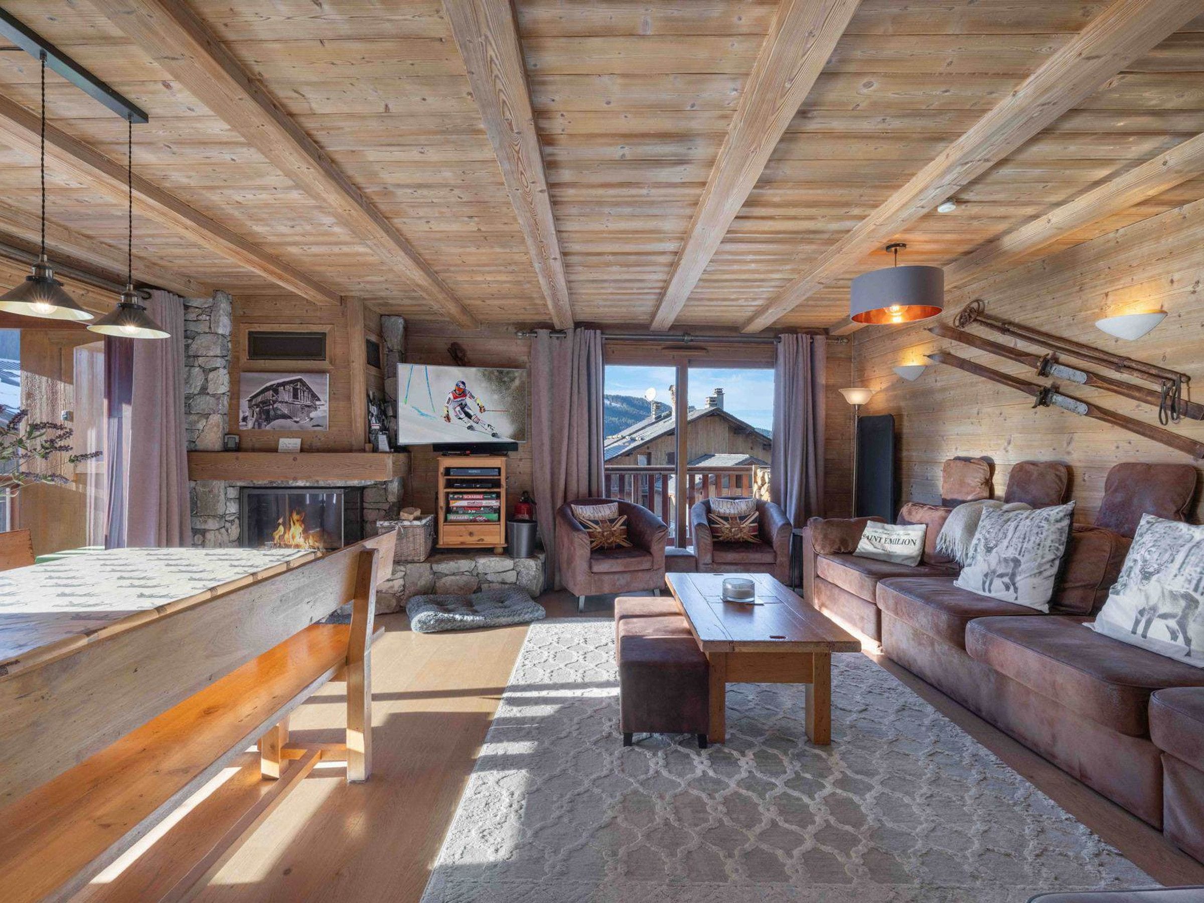 L’intérieur d’un chalet confortable, avec une cheminée, des meubles en bois et un manteau de cheminée en pierre.