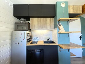 A compact kitchen with a built-in dishwasher, a microwave, and a wooden countertop. - Apartment with wifi, mountain view - 7 guests (Valfréjus)