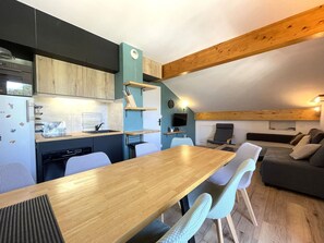A compact kitchen with a dining area, a sofa, and a TV. - Apartment with wifi, mountain view - 7 guests (Valfréjus)