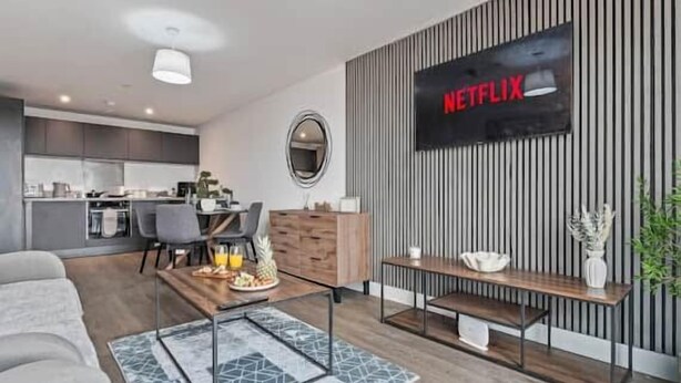 Ein modernes Wohnzimmer mit Flachbildfernseher, Couchtisch und Sofa.