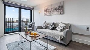 Ein modernes Wohnzimmer mit einer Couch, einem Couchtisch und Blick auf einen Swimmingpool.