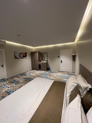 Una habitación de hotel con una cama grande, una mesita de noche, un espejo y un piso estampado.