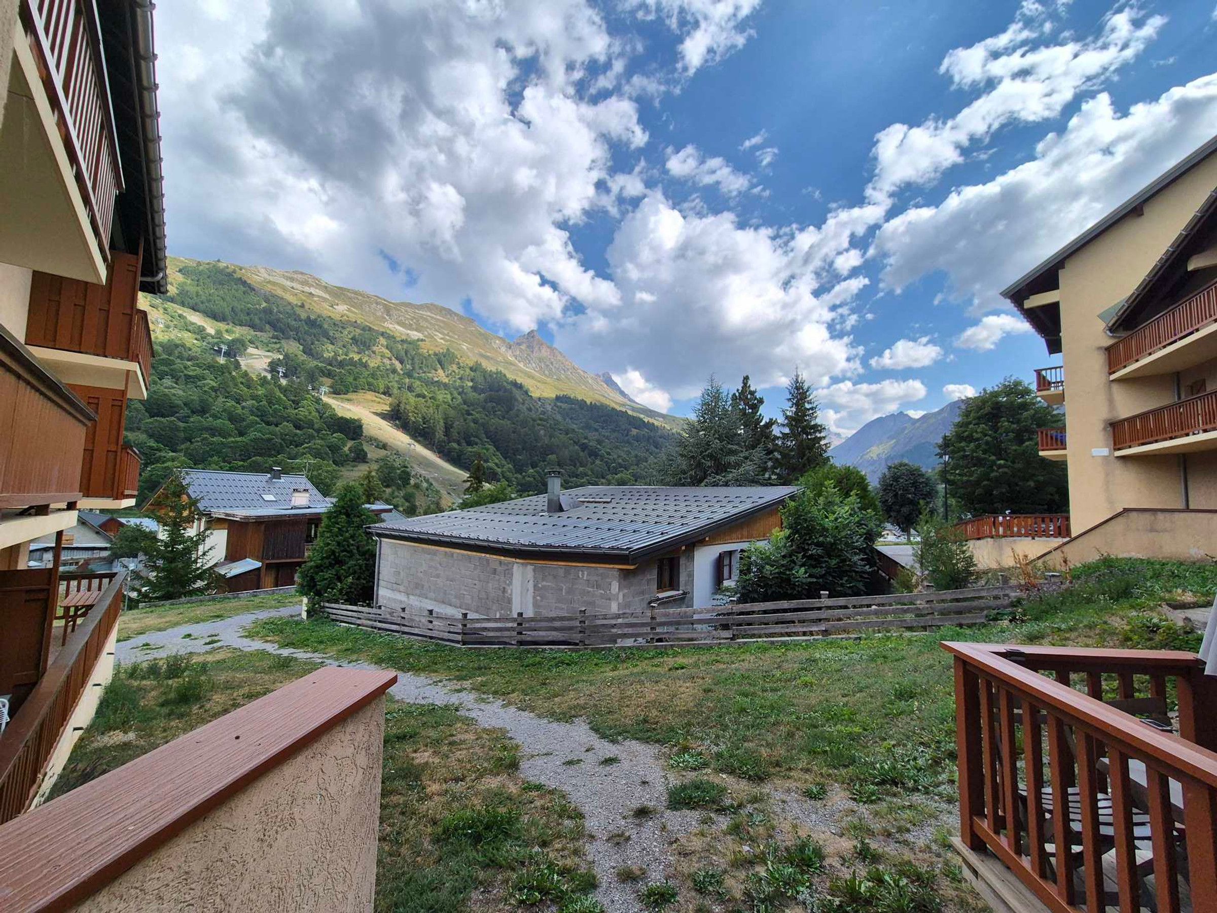 A mountain view with a wooden house and a balcony.