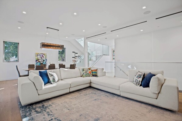 A modern living room with a sectional sofa, a coffee table, and a large window.