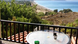A balcony with a table, a green ashtray, and a lantern. - Marvina (Chios)