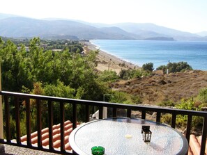 A balcony with a table, a green ashtray, and a lantern. - Marvina (Chios)