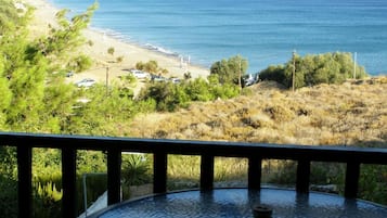 A balcony with a view of a beach and the sea.