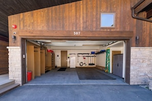 Ett garage med en träfasad, siffran ’307’ ovanför ingången och diverse verktyg och utrustning inuti.