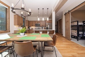 A modern kitchen with wooden cabinets, a central island, and pendant lighting. - Vista Vogue | Hot Tub & Panoramic Views | Downtown (Fraser)