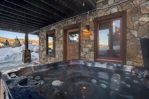 A stone building with a hot tub and a wooden door. - Moose Drool Lodge | Luxury Mountain Lodge | Private Hot Tub (Winter Park)