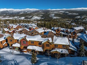 A snow-covered village with wooden houses and a mountain backdrop. - Hygge Hideaway | Private Hot Tub (Winter Park)