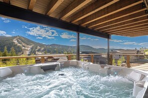 Ein Whirlpoolbereich mit Blick auf Berge und einer Holterrasse.