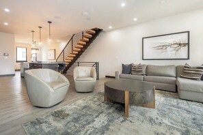 A modern living room with a staircase, a sofa set, and a coffee table. - Arrow Reserve | Pet Friendly | Downtown Dream | Hot Tub (Winter Park)