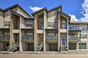 A multi-story building with a central staircase, balconies, and a garage entrance. - Rendezvous Retreat | Pet Friendly with Peak Vistas | Walk to Trails (Fraser)