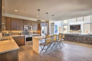 A modern kitchen with a central island, stainless steel appliances, and pendant lighting. - Rendezvous Retreat | Pet Friendly with Peak Vistas | Walk to Trails (Fraser)