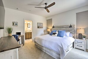 A bedroom with a bed, bedside tables, a ceiling fan, and a view into the bathroom. - Rendezvous Retreat | Pet Friendly with Peak Vistas | Walk to Trails (Fraser)