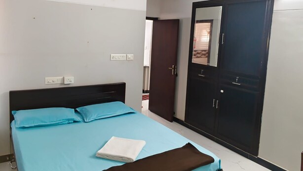Quarto com cama, guarda-roupa e porta.