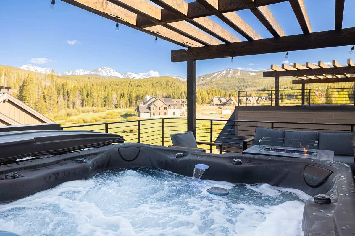 Un bain à remous avec vue sur les montagnes et les maisons.