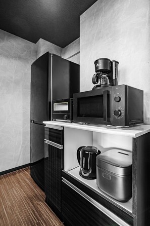 A compact kitchen with a built-in microwave, coffee maker, and a small oven. - Edgewater Terrace 211 (Sapporo)