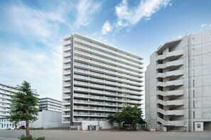 A multi-story parking garage with a modern design, featuring a series of balconies and a covered pedestrian area. - Edgewater Terrace 211 (Sapporo)