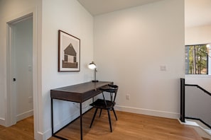 A room with a desk, chair, and a framed picture on the wall. - Lumen Haus | Pet Friendly | Modern Mountain Home (Fraser)