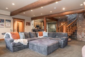 A spacious living room with a sectional sofa, a fireplace, and a stone accent wall. - Lakota Cedarcrest | Large & Luxe | Private Hot Tub | Resort Views (Winter Park)