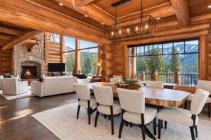 A log cabin interior with a fireplace, a dining area, and a sofa set. - Lakota Cedarcrest | Large & Luxe | Private Hot Tub | Resort Views (Winter Park)