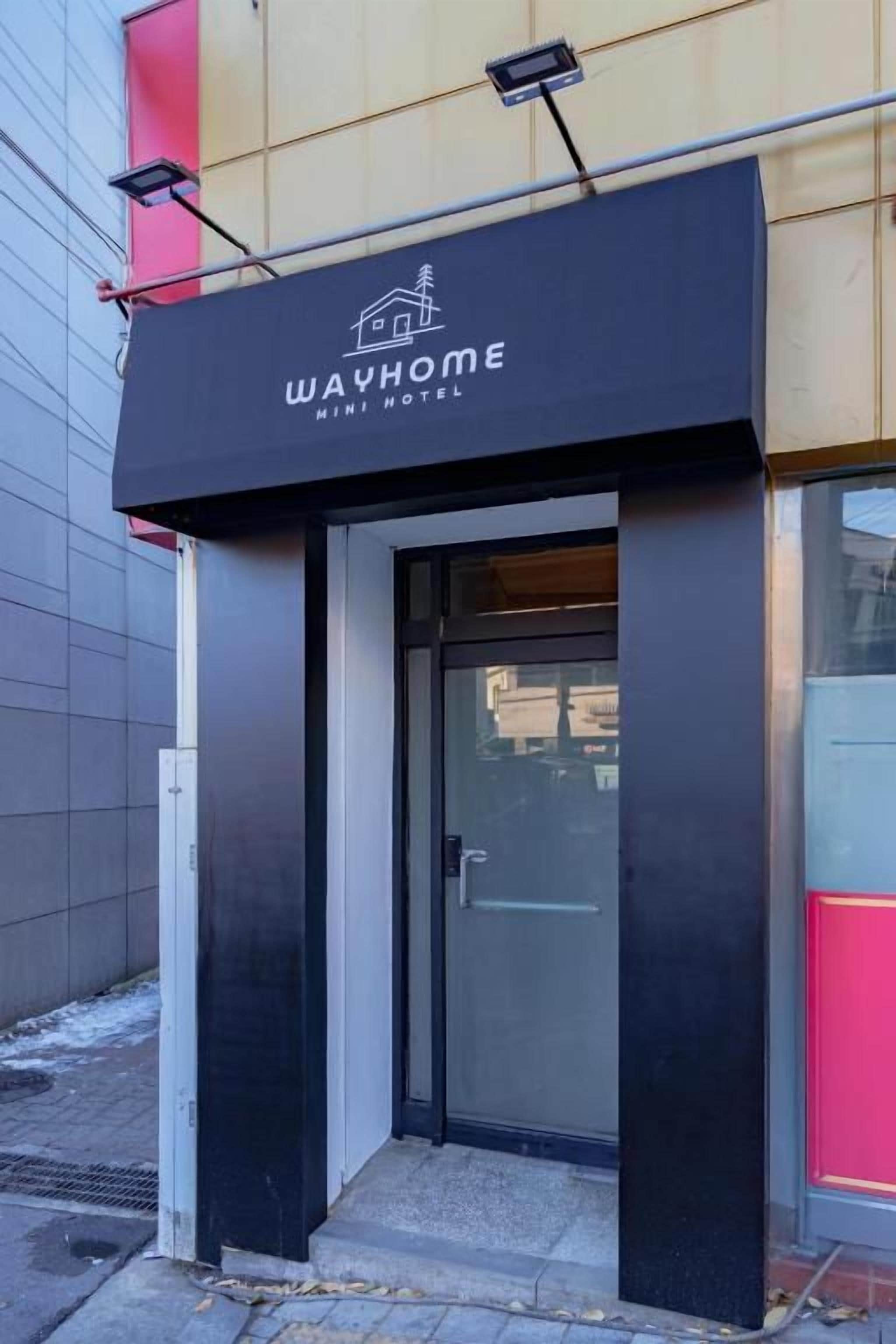 A black awning with 'WAYHOME MINI HOTEL' written on it.