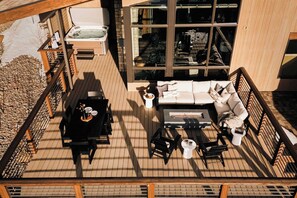 An outdoor deck with a hot tub, a sofa set, and a barbecue area. - Lakota Lookout | Private Hot Tub | Slope Views (Winter Park)