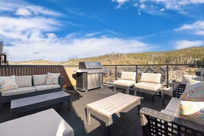 An outdoor patio with a sofa, chairs, a table, and a grill. - Solstice Abode | Pet Friendly | Private Hot Tub | Prime Location (Winter Park)