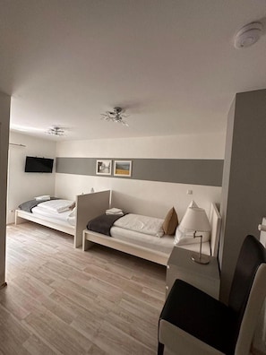 Un dormitorio con cama, mesita de noche, lámpara y ventilador de techo.
