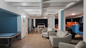 A room with a pool table, seating area, and a vehicle. - A Home away from home (Fajardo)