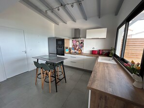 Eine moderne Küche mit Essbereich, integrierten Geräten und einem Fenster mit Ausblick.