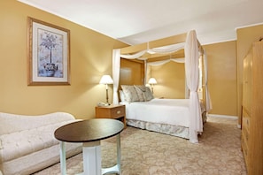 Een hotelkamer met een bed, nachtkastjes, een tafel en een bank.