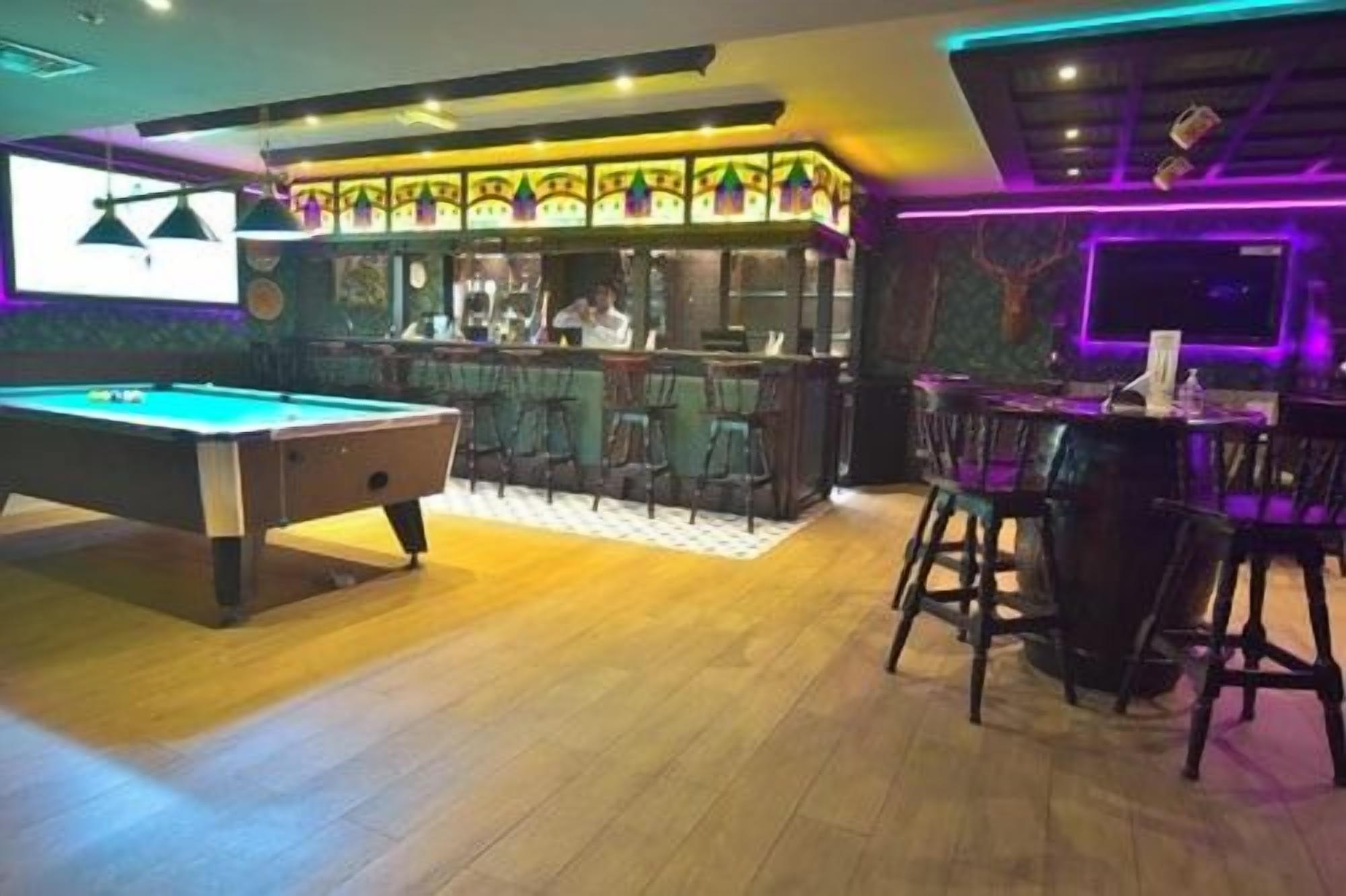 Een pooltafel met een bar en zitplaatsen.