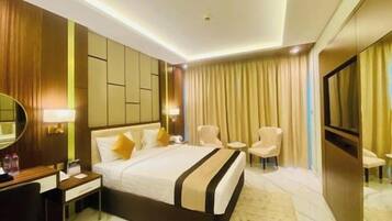Une chambre d’hôtel avec un grand lit, des tables de chevet, un bureau et une chaise.