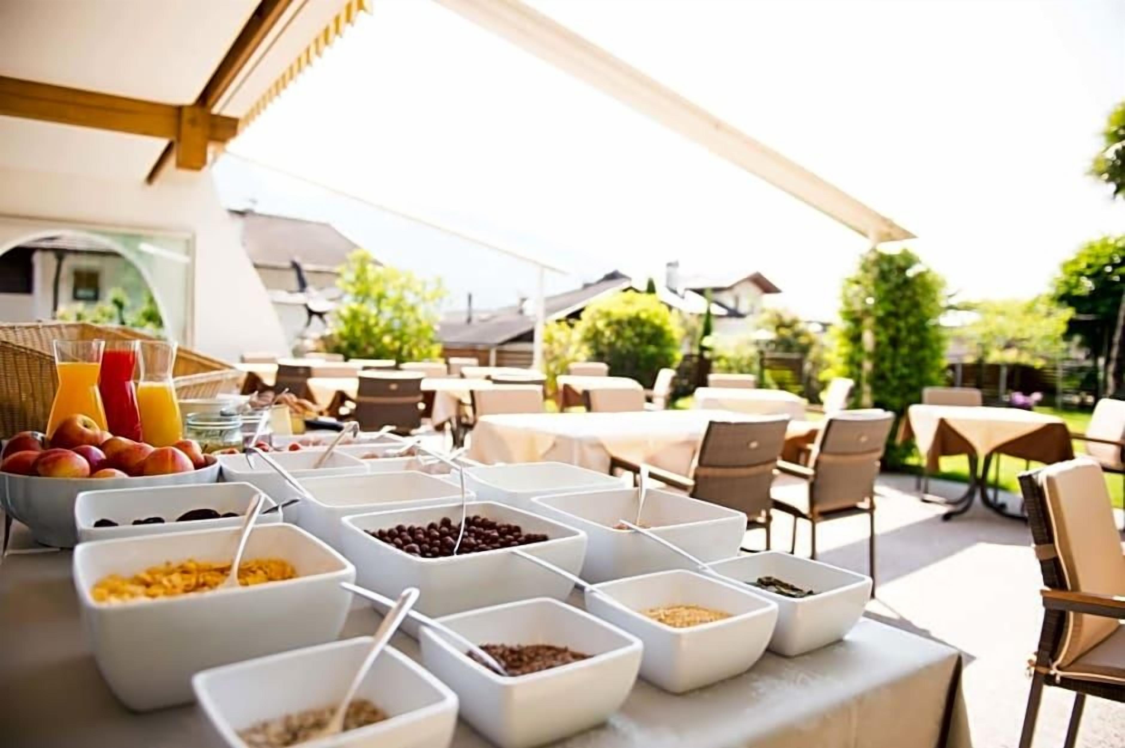 Un ricco buffet per la colazione all'aperto, con diverse pietanze e postazioni per sedersi.
