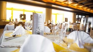 A restaurant setting with tables set for dining, menus, and wine glasses. - Paradies (Marlengo)