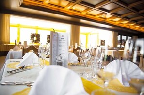A restaurant setting with tables set for dining, menus, and wine glasses. - Paradies (Marlengo)