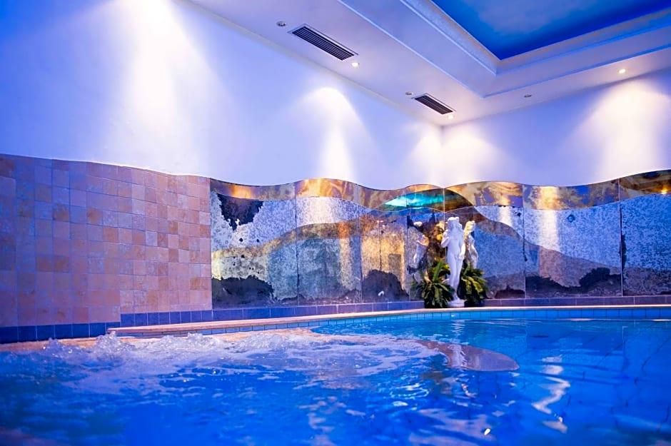 Una piscina interna con parete piastrellata e soffitto con illuminazione a incasso.