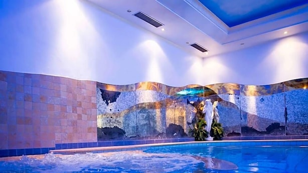 An indoor swimming pool with a tiled wall and a ceiling with recessed lighting. - Paradies (Marlengo)