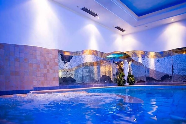 An indoor swimming pool with a tiled wall and a ceiling with recessed lighting. - Paradies (Marlengo)